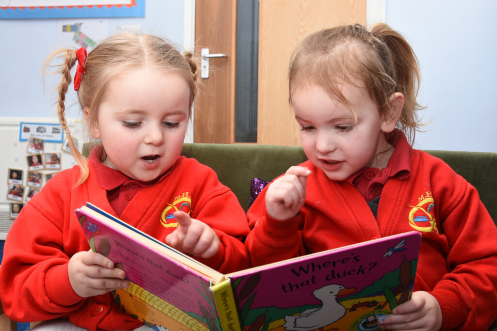 Two Manor Hill First School pupils read a book titled "Where's that duck?".