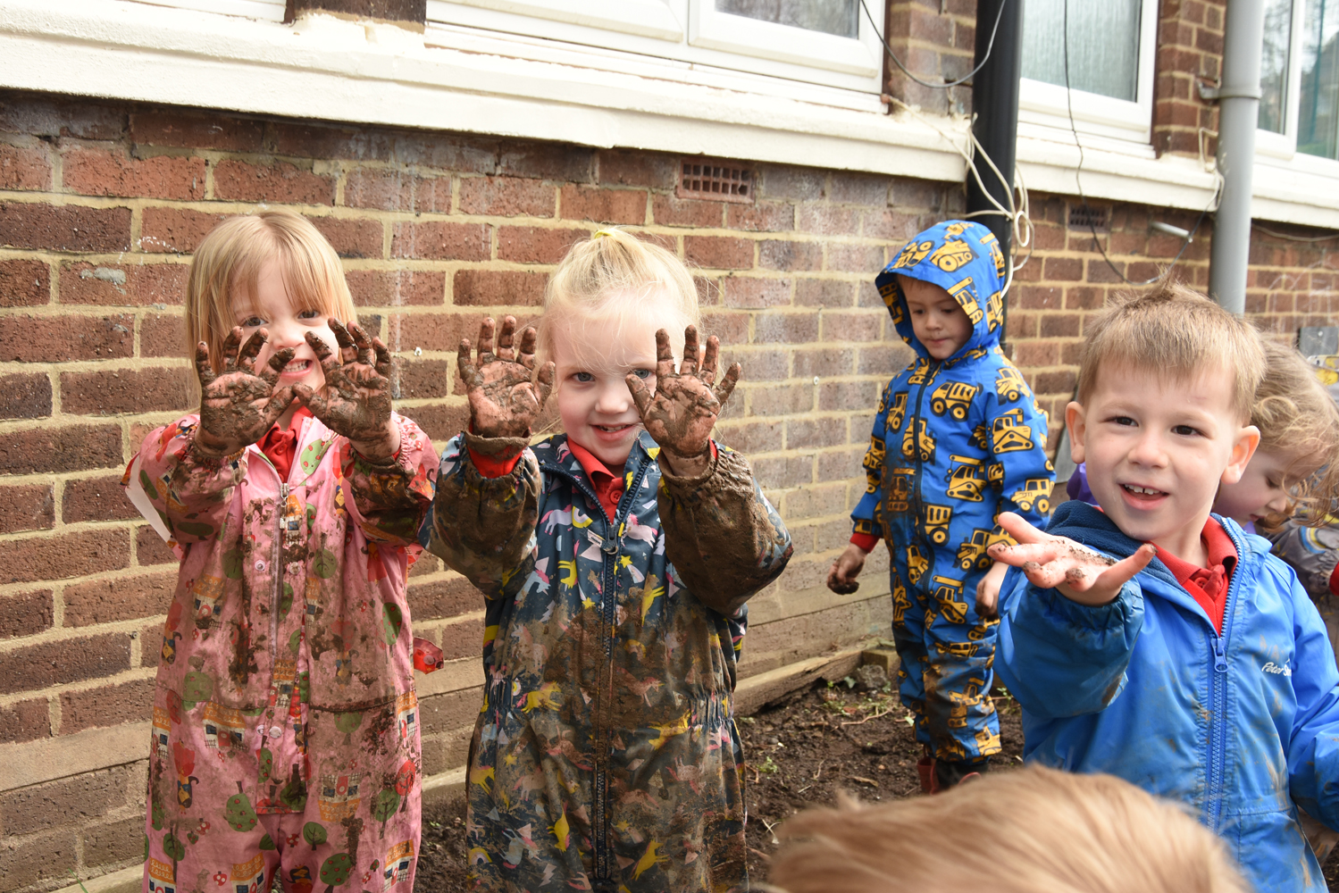 Early Explorers at Manor Hill First show their muddy hands while exploring one of our outdoor play areas