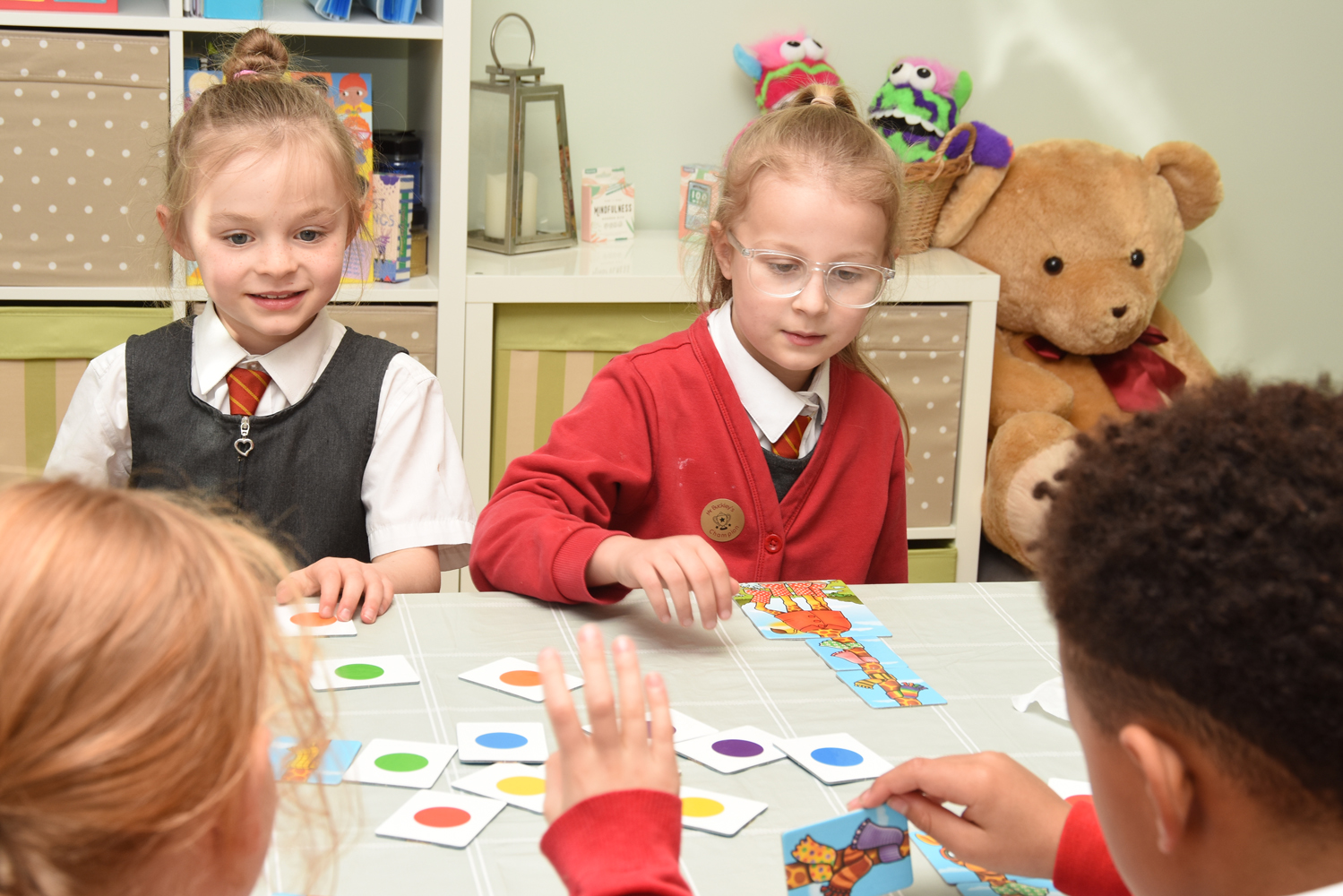 Four pupils seated around a table playing a matching game.